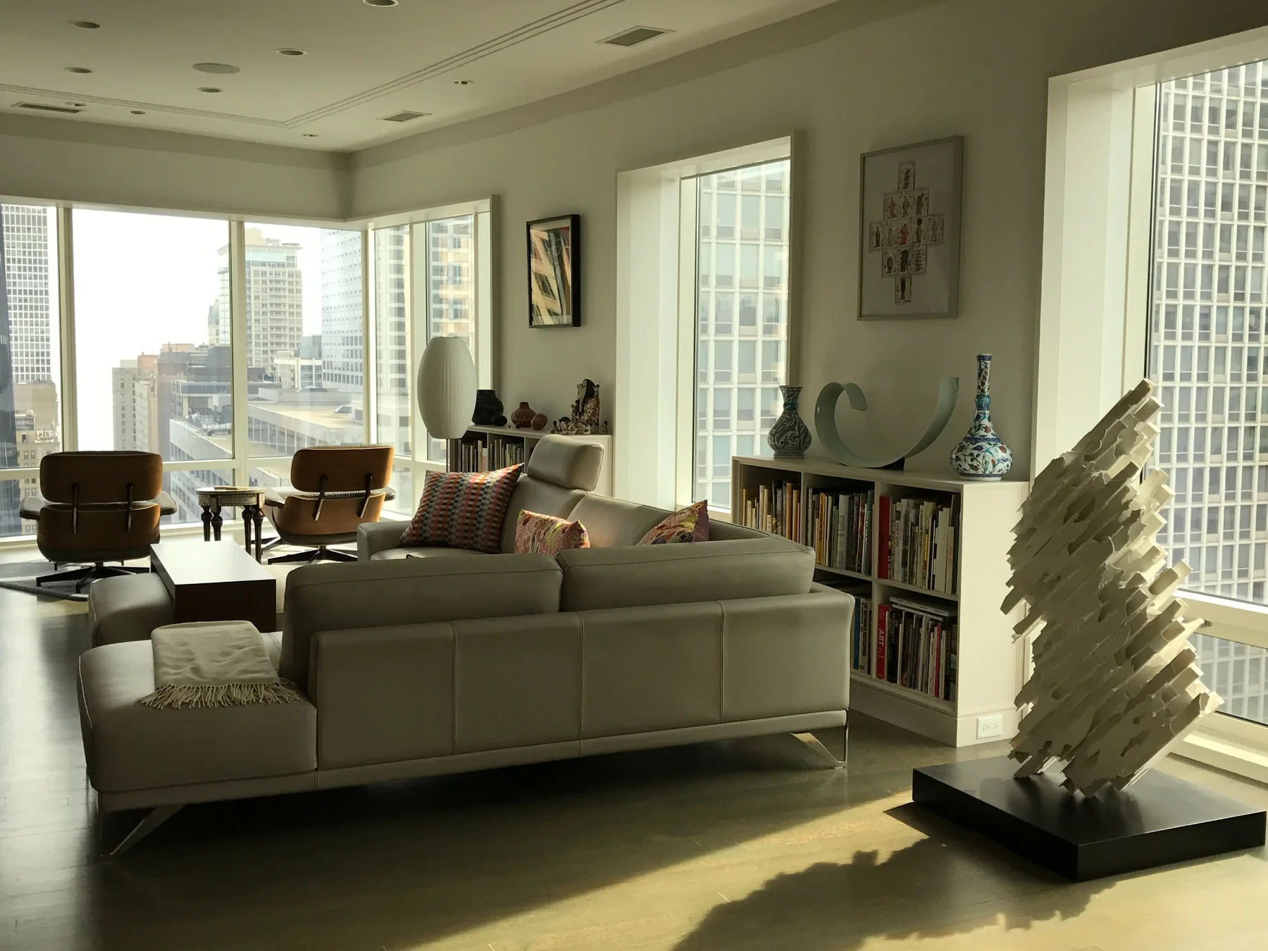 Contemporary city residence with sculpture, books, modern furniture, and panoramic windows