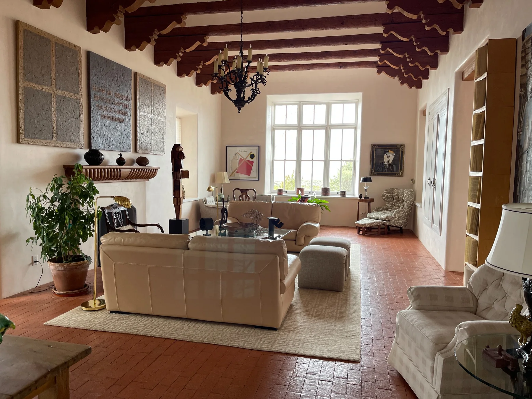 Santa Fe living room with traditional vigas, collected artwork, sculpture, and contemporary furnishings