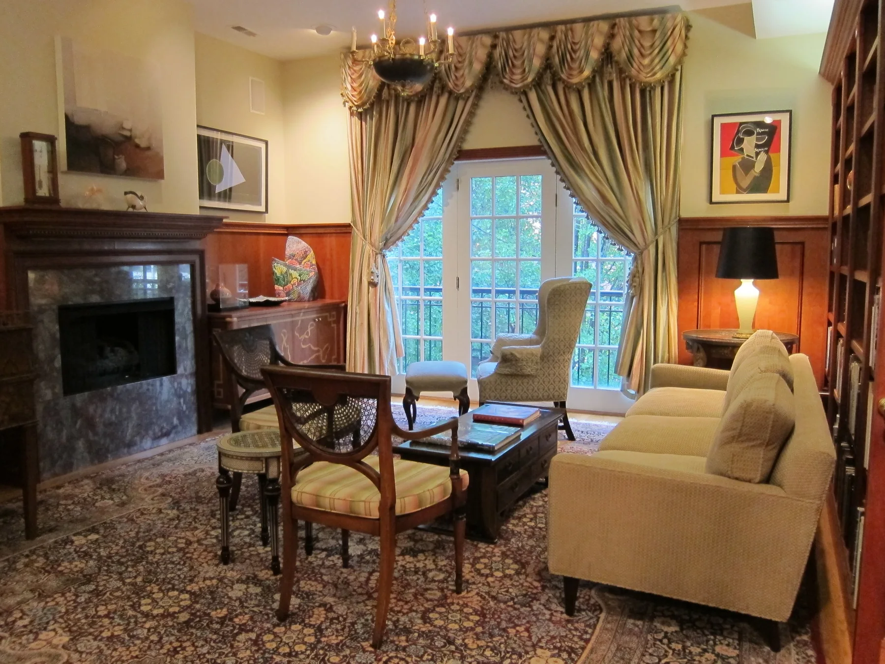 Traditional library with drapery, fireplace, art, antiques, and upholstered seating